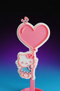 Hello Kitty headphone stand with black headphones on a desk