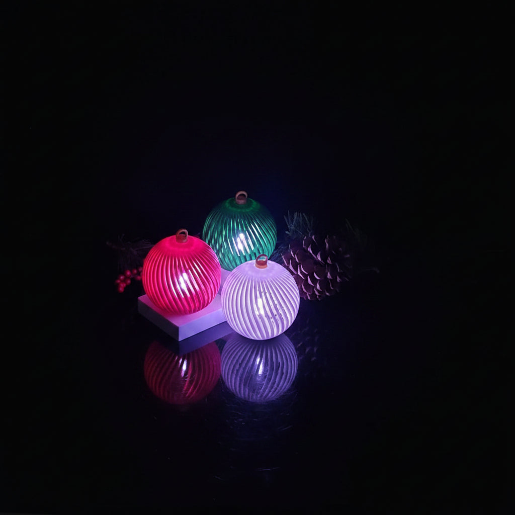 3D printed holiday LED ornaments glowing in red, green, and yellow with flameless tea light inside