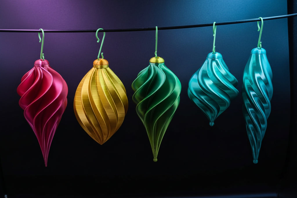 Holiday vase mode ornaments in red, yellow, green, teal, and light teal hanging on a rack