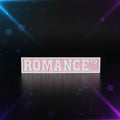 3D printed Romance Rd street sign in pink and white displayed in front of Fourth Wing and other BookTok books on a shelf