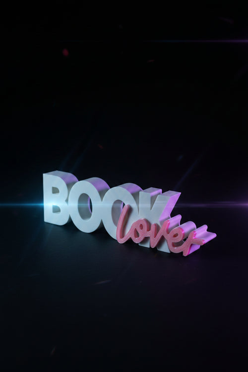 3D printed Book Lover sign standing upright with dried floral arrangement