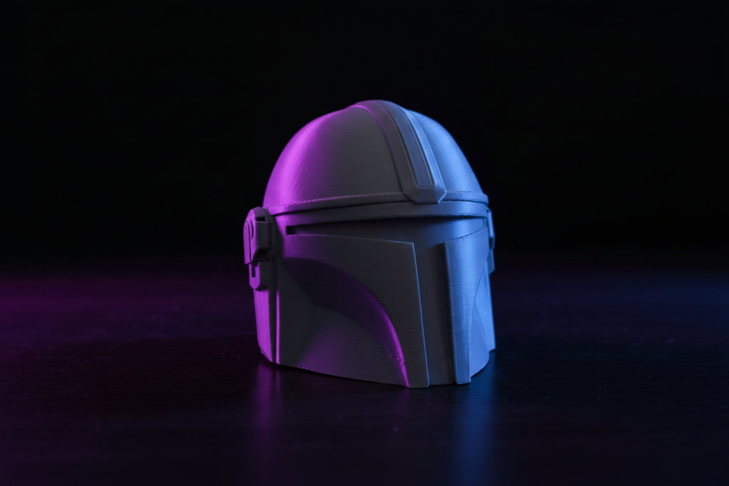 Mandalorian tow hitch cover installed on a vehicle bumper in a forest setting