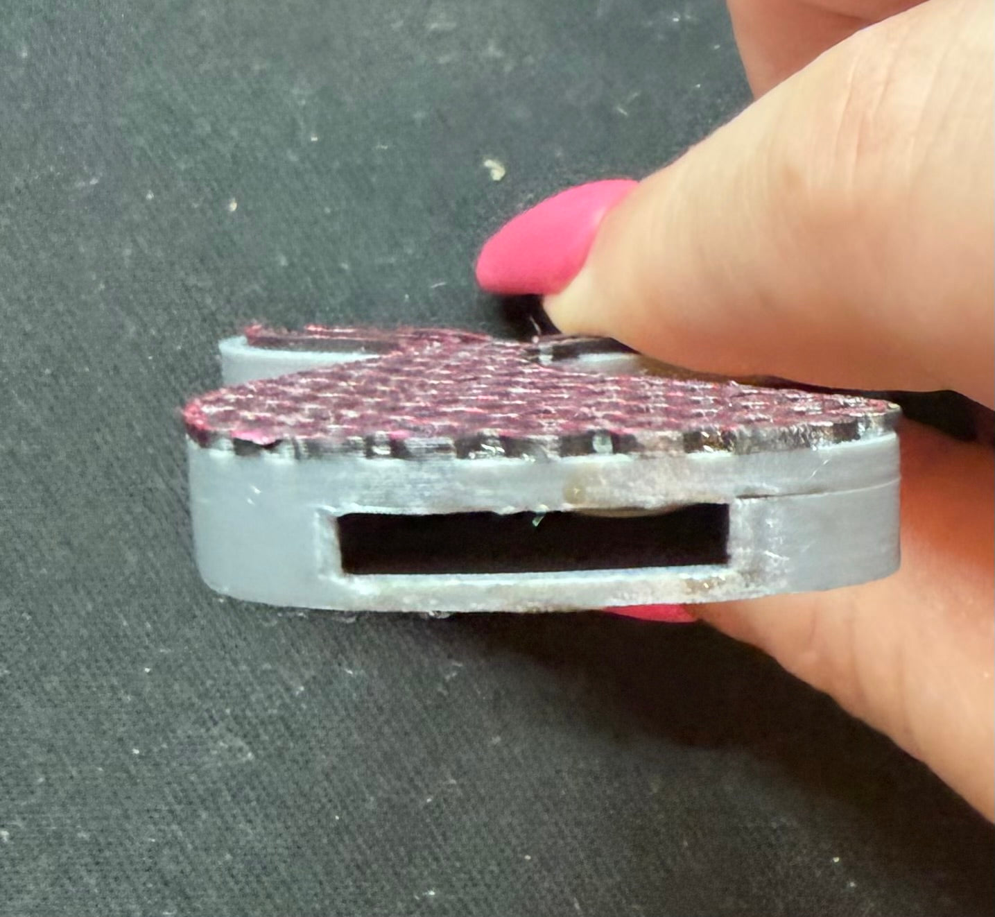 Close-up of mermaid tail can opener showing the slot that fits under a soda can tab